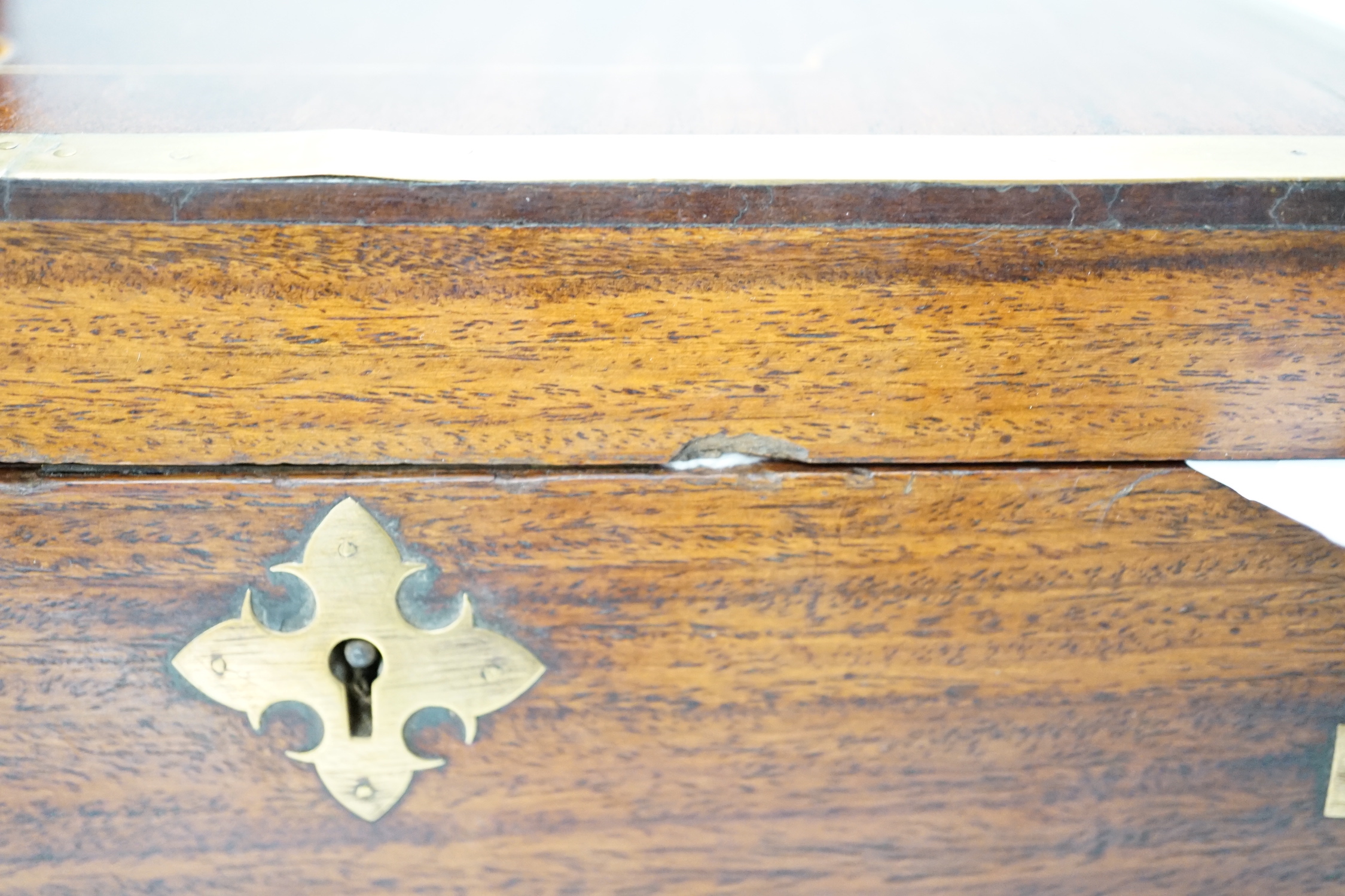 An Anglo-Indian wooden brass bound sewing box, with fitted interior and removable sections, hinged bevelled mirror, internal glass lid, etc. lock marked Birmingham, 26cm x 31cm x 14cm